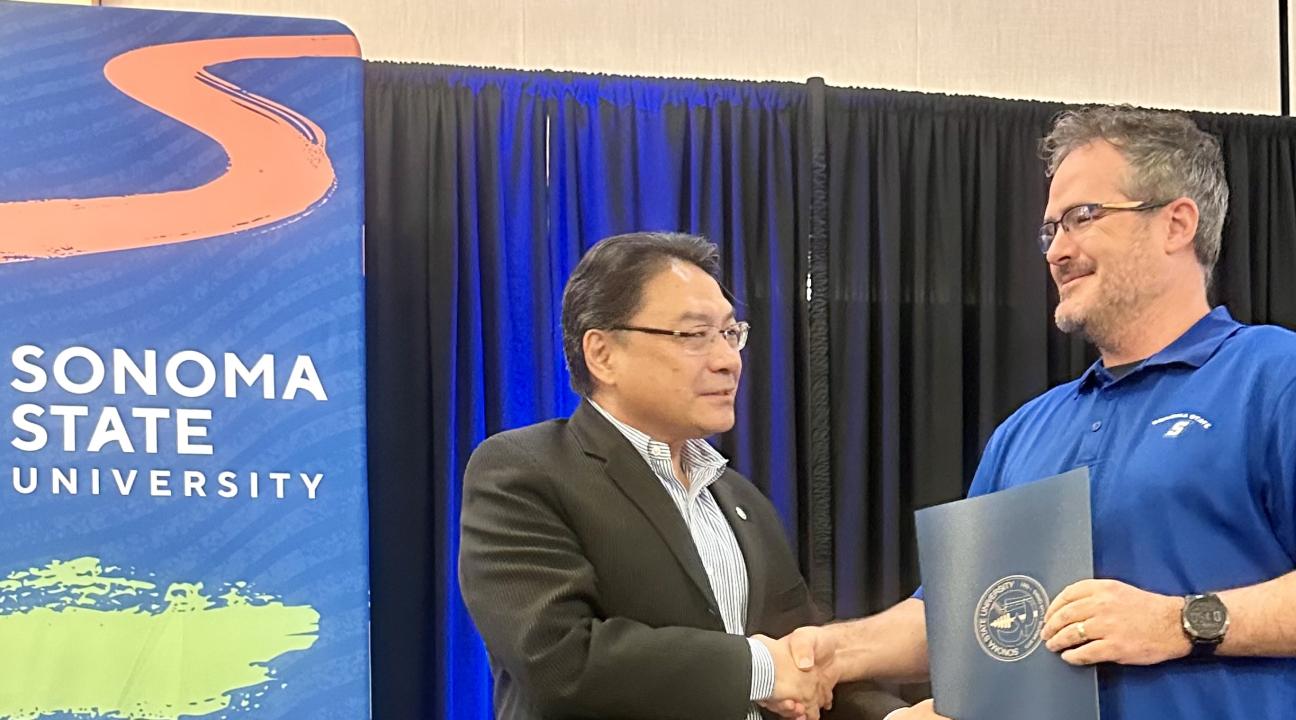 Dr. Lee presenting award to Chris Hendry