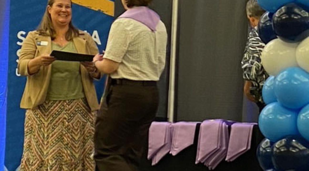 person handing certificate to graduate
