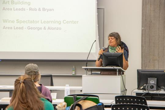 Christa Irwin speaking at lecturn