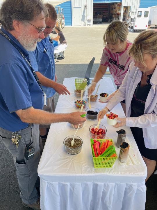 group of people scooping toppings into bowls