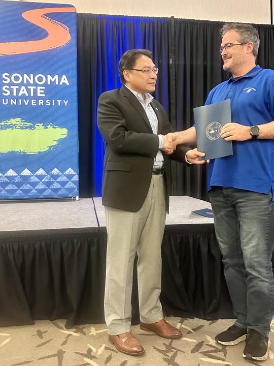 Dr. Lee presenting award to Chris Hendry