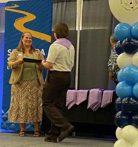 person handing certificate to graduate