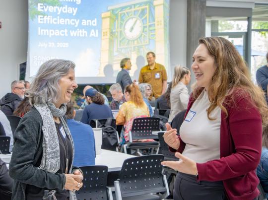 Colleagues chatting and laughing at Summer AI Day